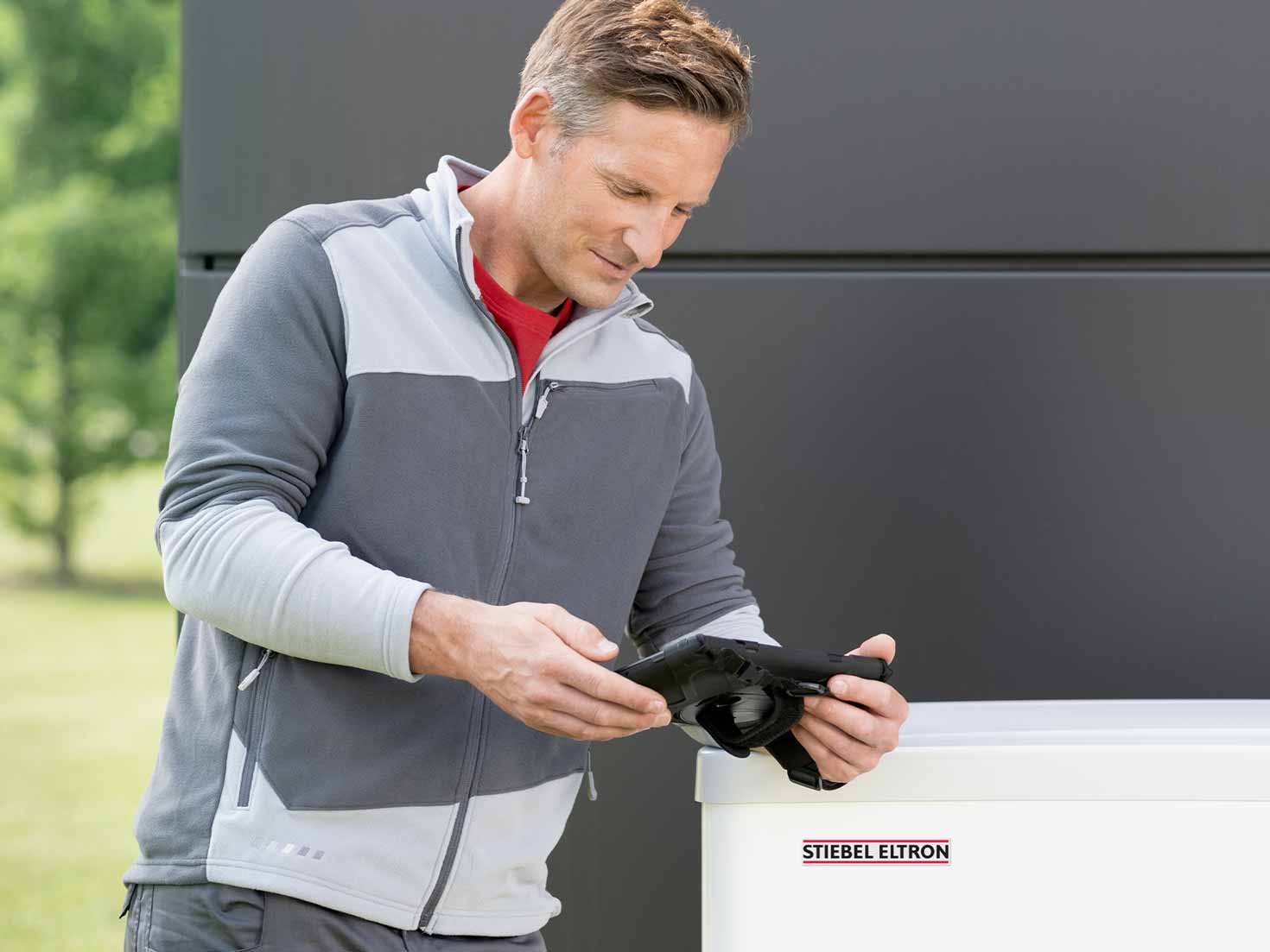 Fachhandwerker schaut auf sein Tablet