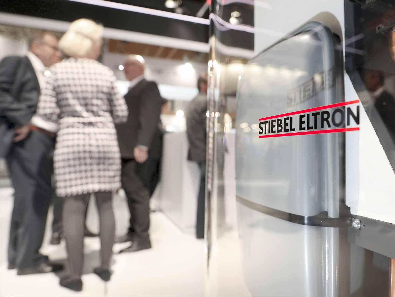 Zwei Geschäftsmänner im Gespräch an einer Warmwasserwärmepumpe