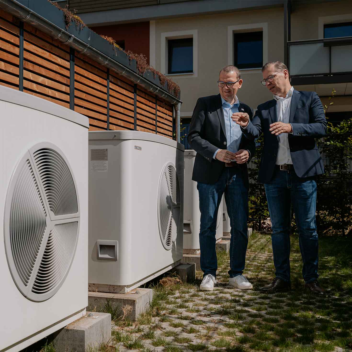 Zwei Männer im Gespräch an einer Wärmepumpenkaskade