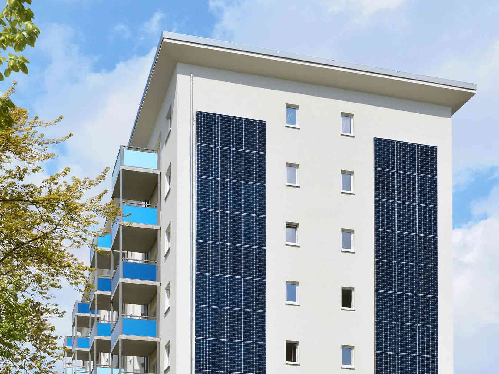 Weißes Mehrfamilienhaus mit Solarfront