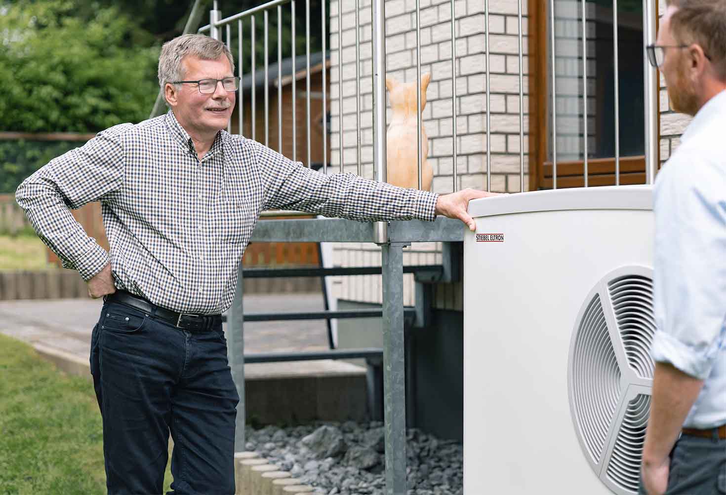 Mann steht an einer Wärmepumpe von STIEBEL ELTRON