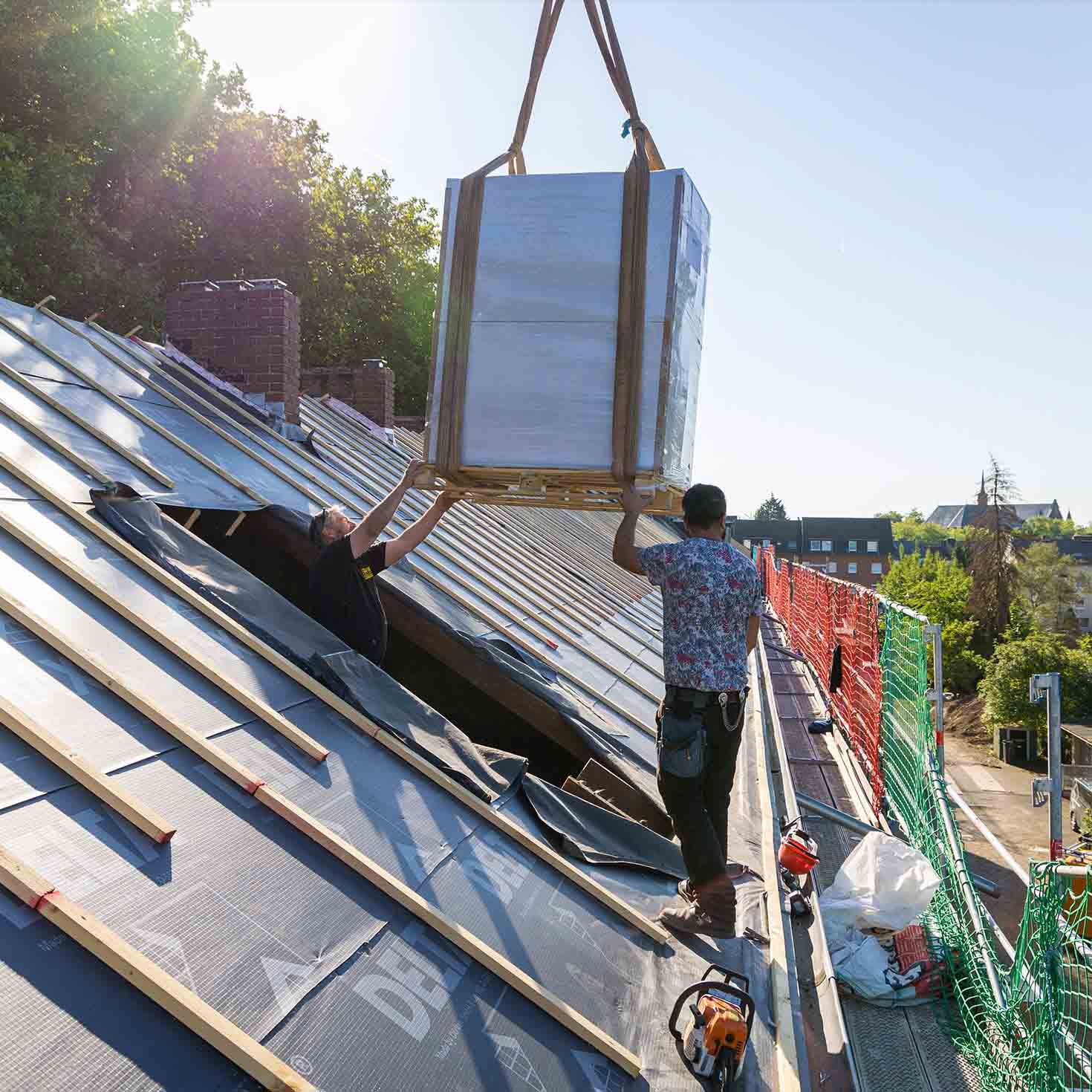 Wärmepumpe wird mit Kran in ein Dachgeschoss gehoben