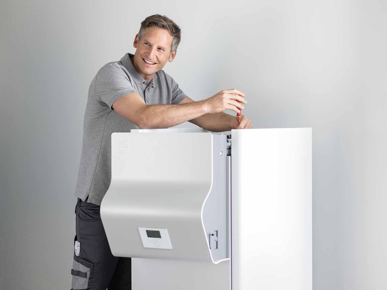 Ein Fachhandwerker installiert eine Sole-Wasser-Wärmepumpe