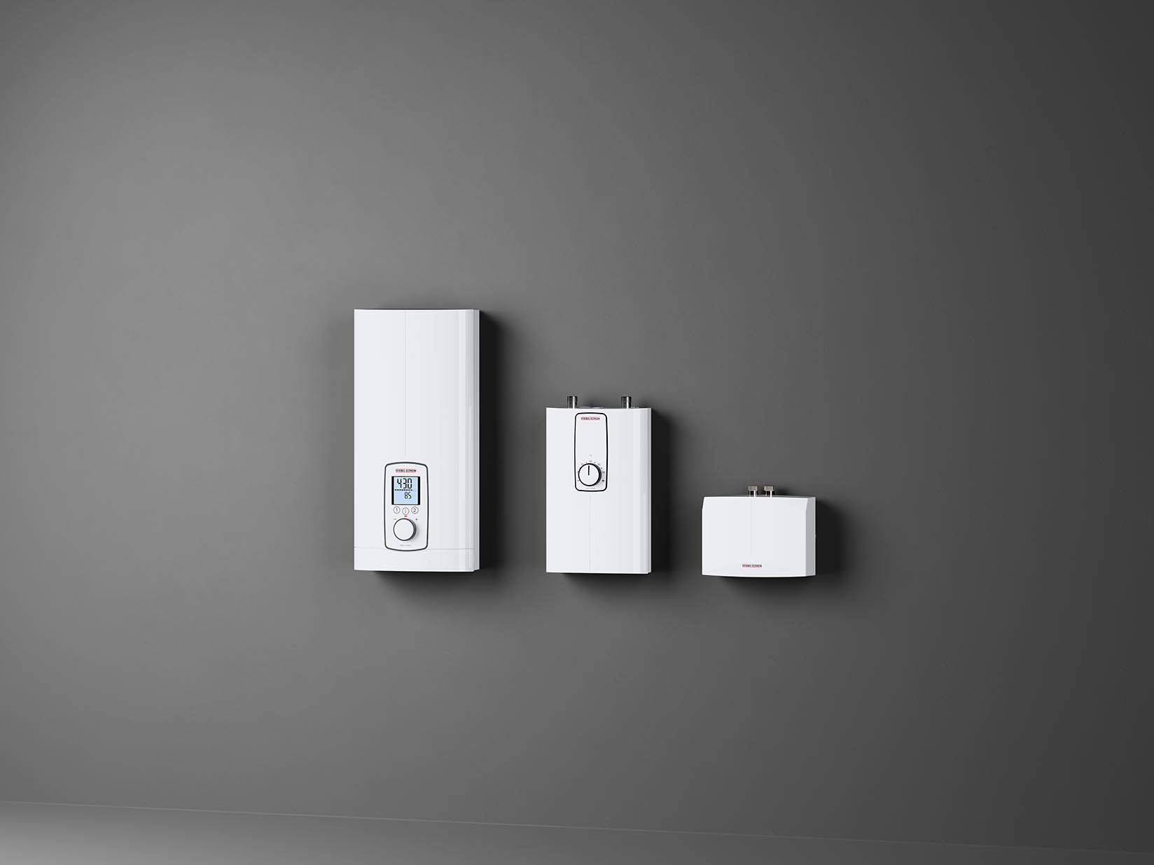 STIEBEL ELTRON-Komfort-, Kompakt und Mini-Durchlauferhitzer hängen an grauer Wand