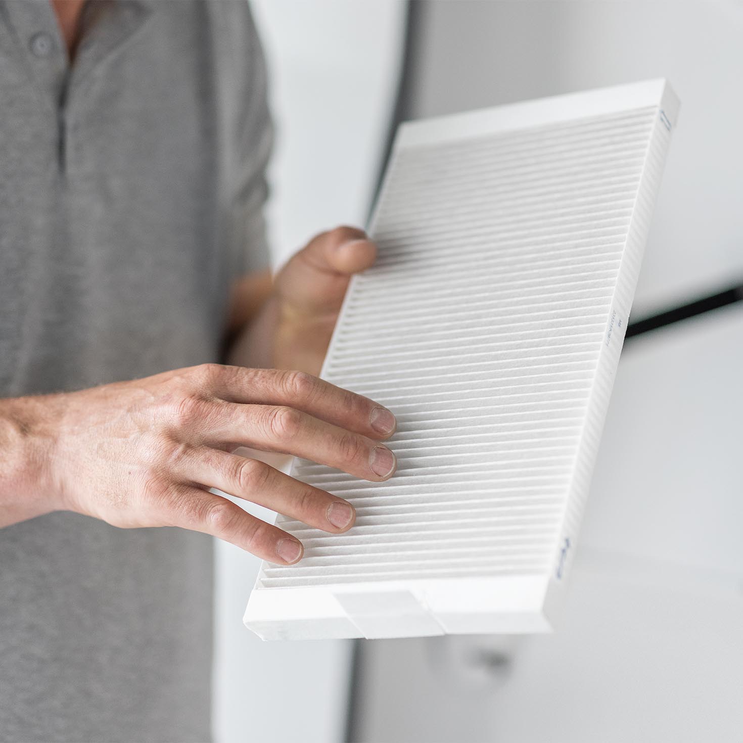 Mann hält Filter für Lüftungsanlagen in den Händen