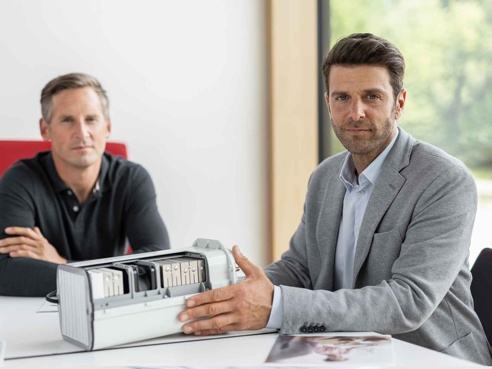 Zwei Männer demonstrieren ein dezentrales Lüftungsgerät von STIEBEL ELTRON
