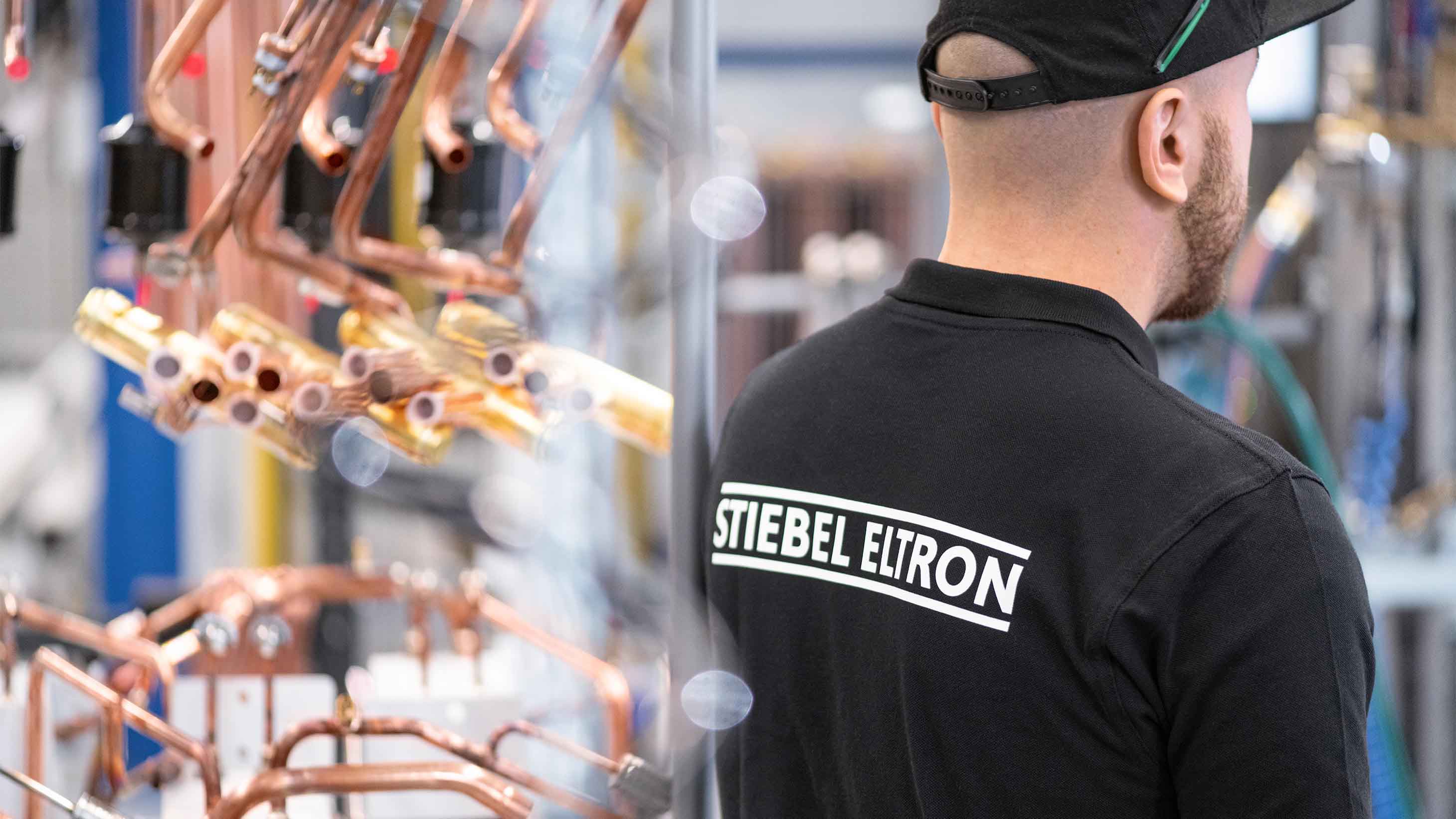 Mann mit STIEBEL ELTRON T-Shirt in einer Fertigungshalle