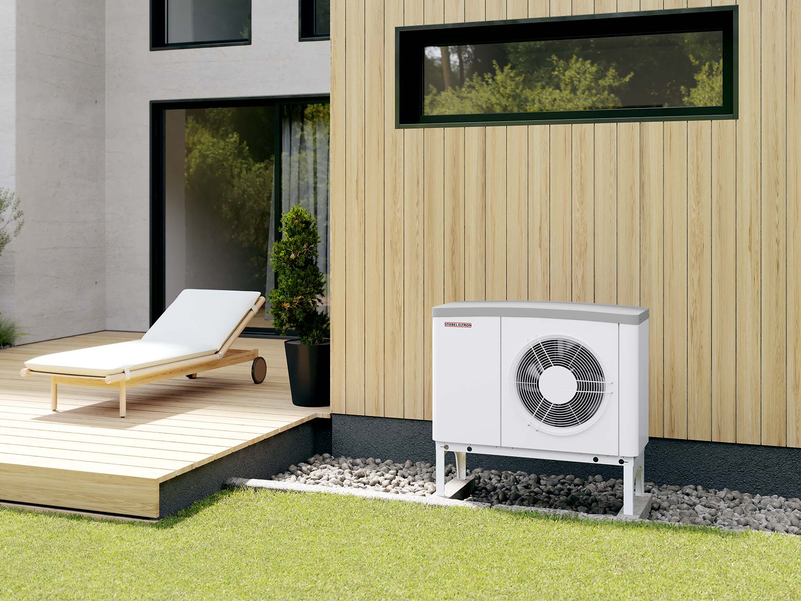 Die Luftwärmepumpe WPL ACS classic von STIEBEL ELTRON steht im Garten vor der Hauswand