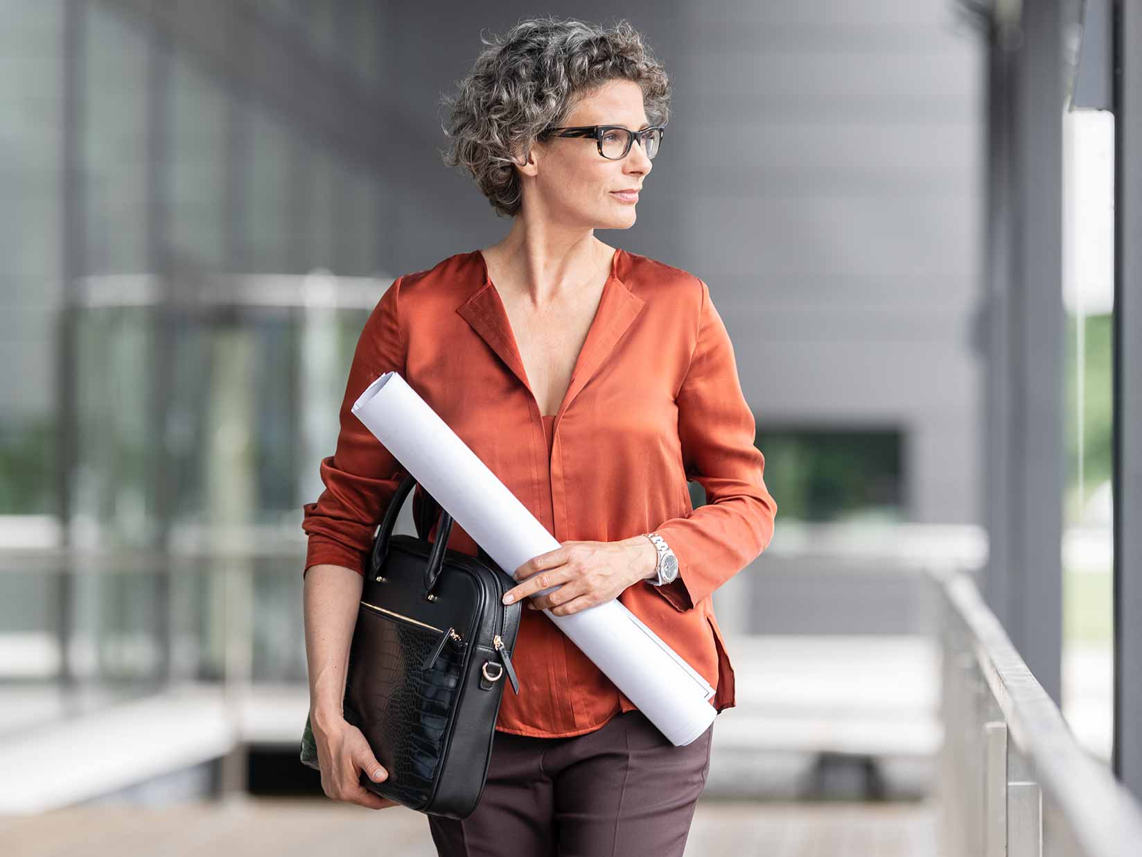 Eine Frau mit einem Bauplan und einer Aktentasche