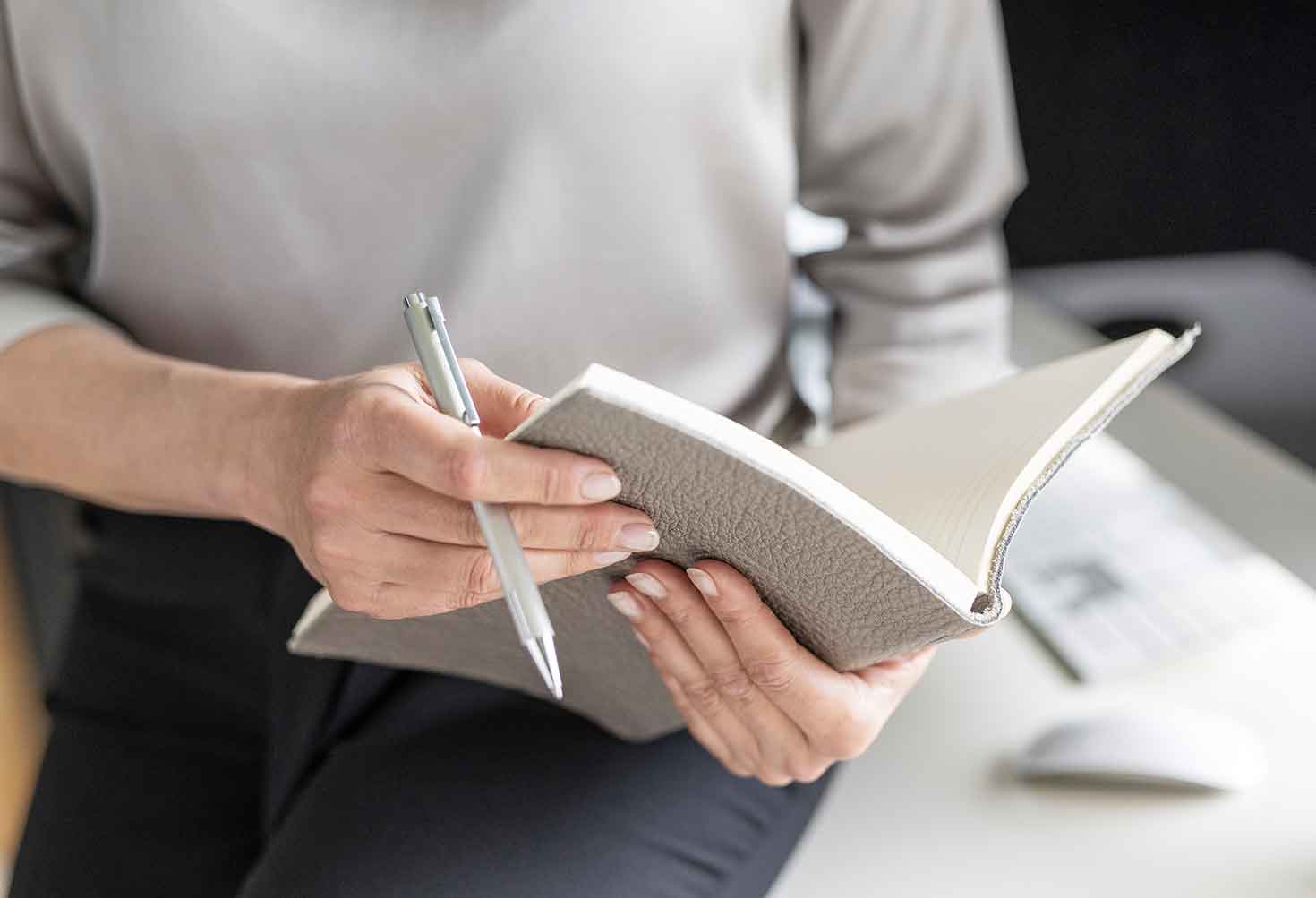 Frau hält Notizbuch in der Hand