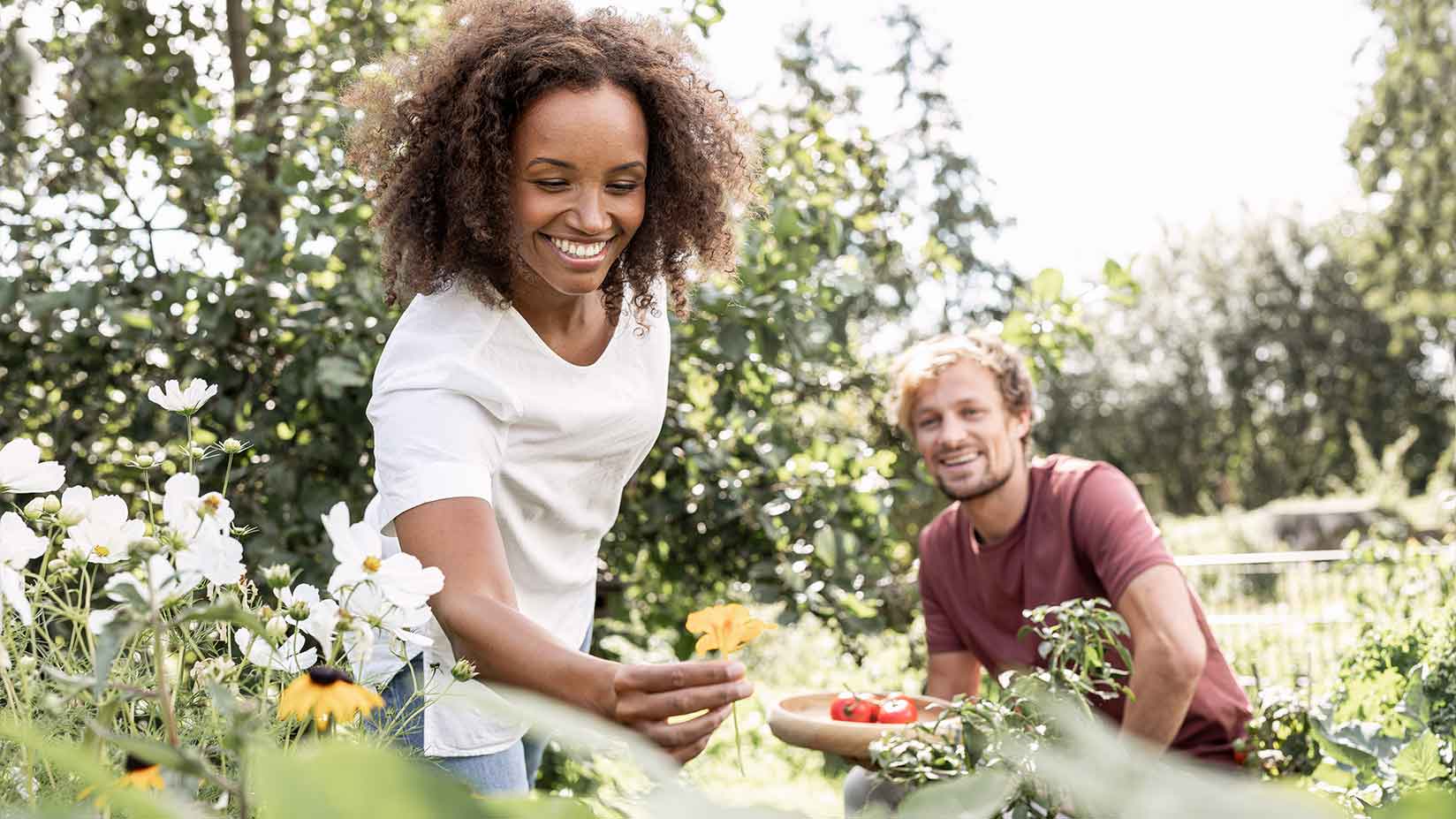 Eine Frau pflückt Blumen in ihrem Garten