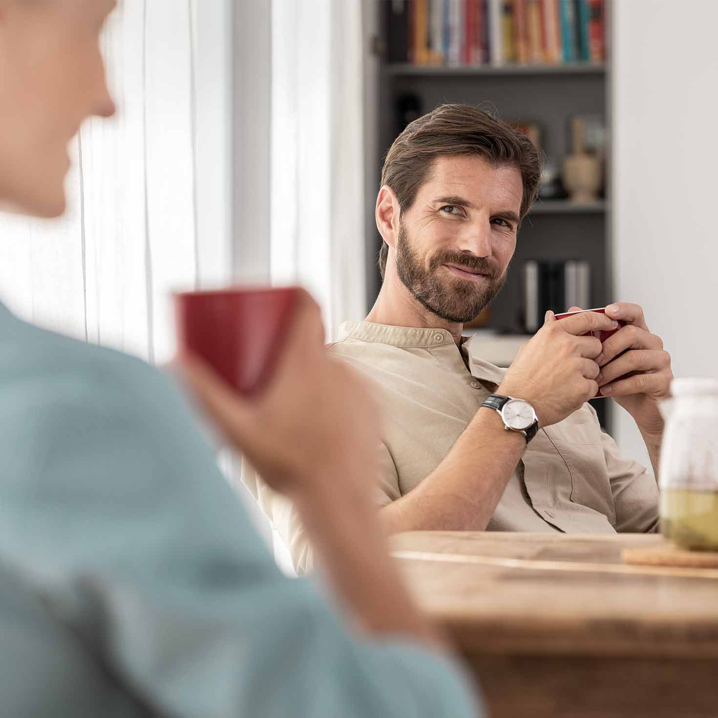 Ein Mann sitzt am Tisch und trinkt eine Tasse Tee