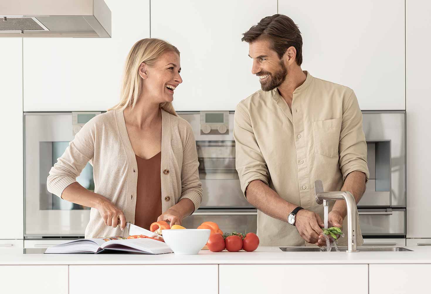 Pärchen lacht und kocht gemeinsam in der Küche