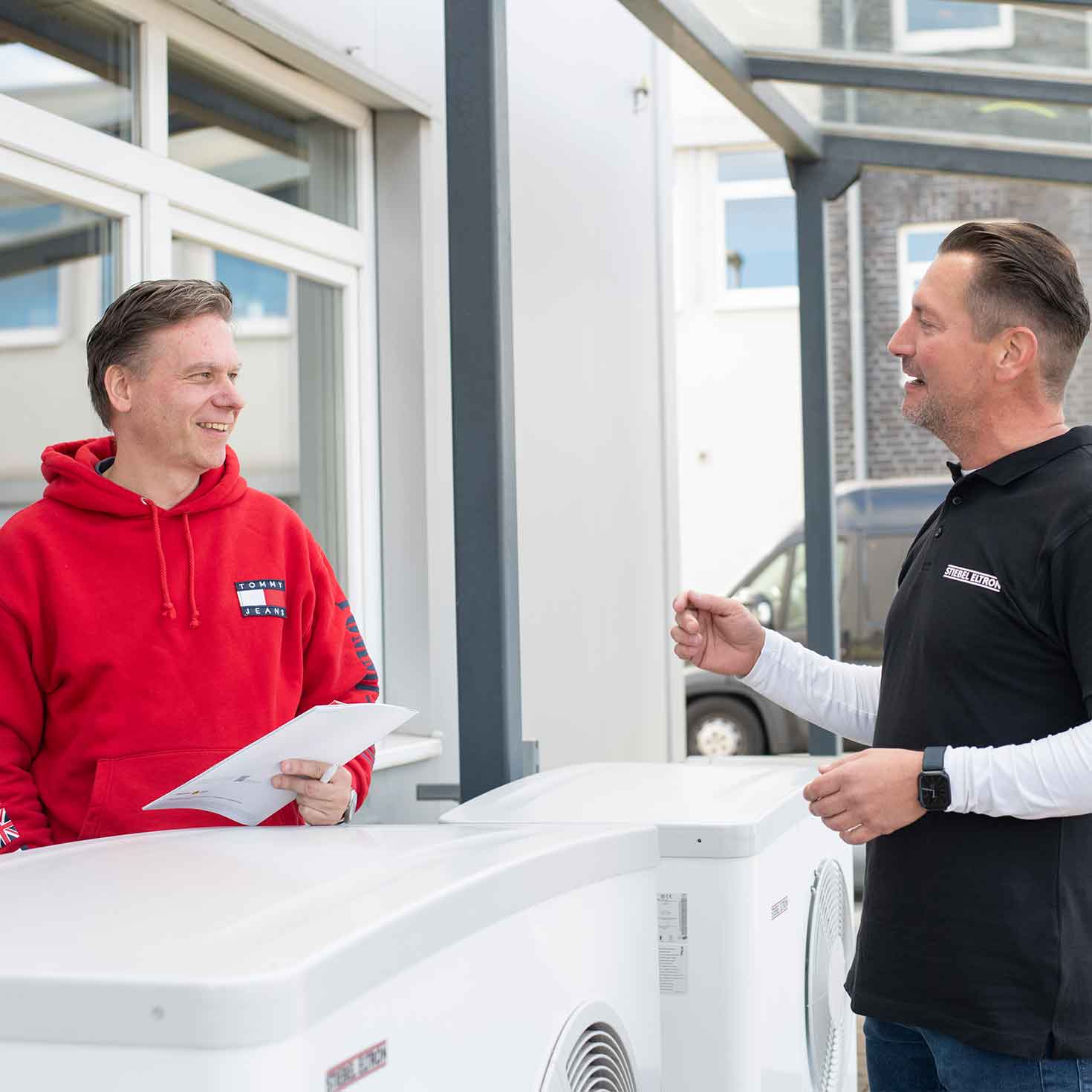Zwei Männer im Gespräch an einer Wärmepumpe
