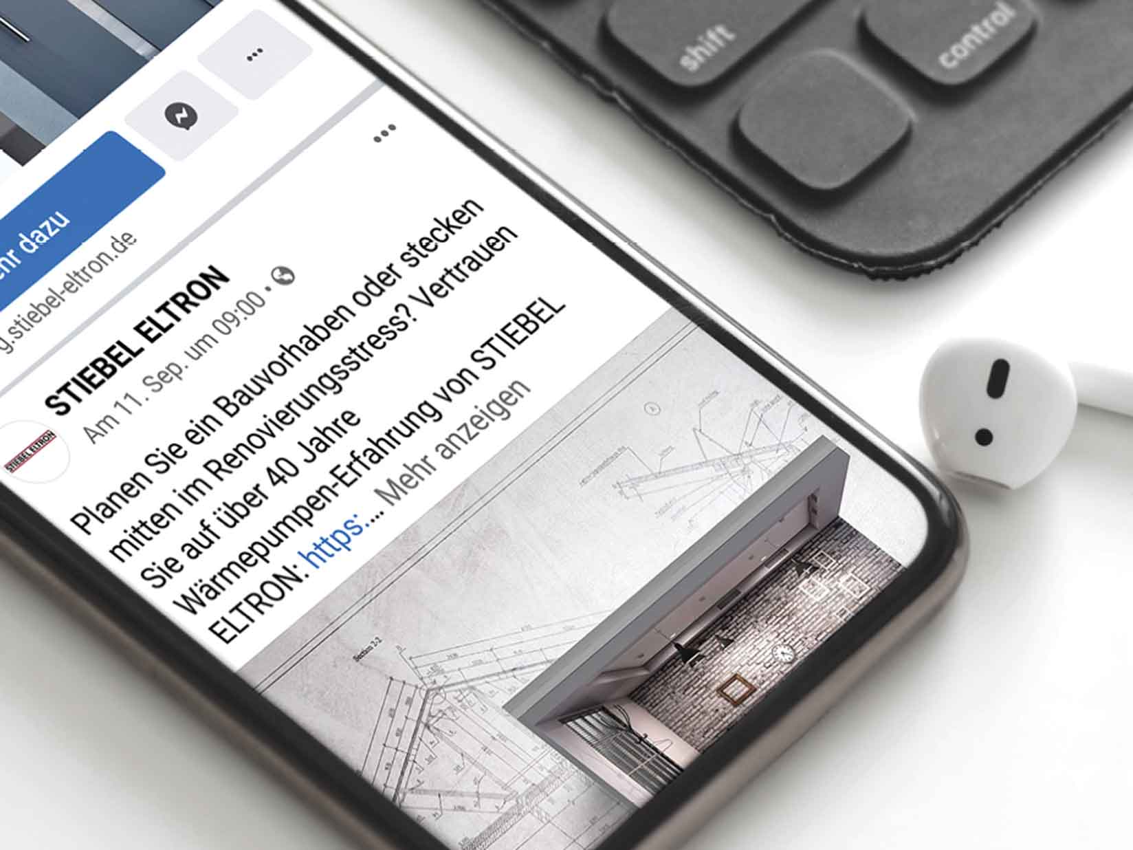 Auf dem Handybildschirm wird ein Facebook-Post von STIEBEL ELTRON angezeigt