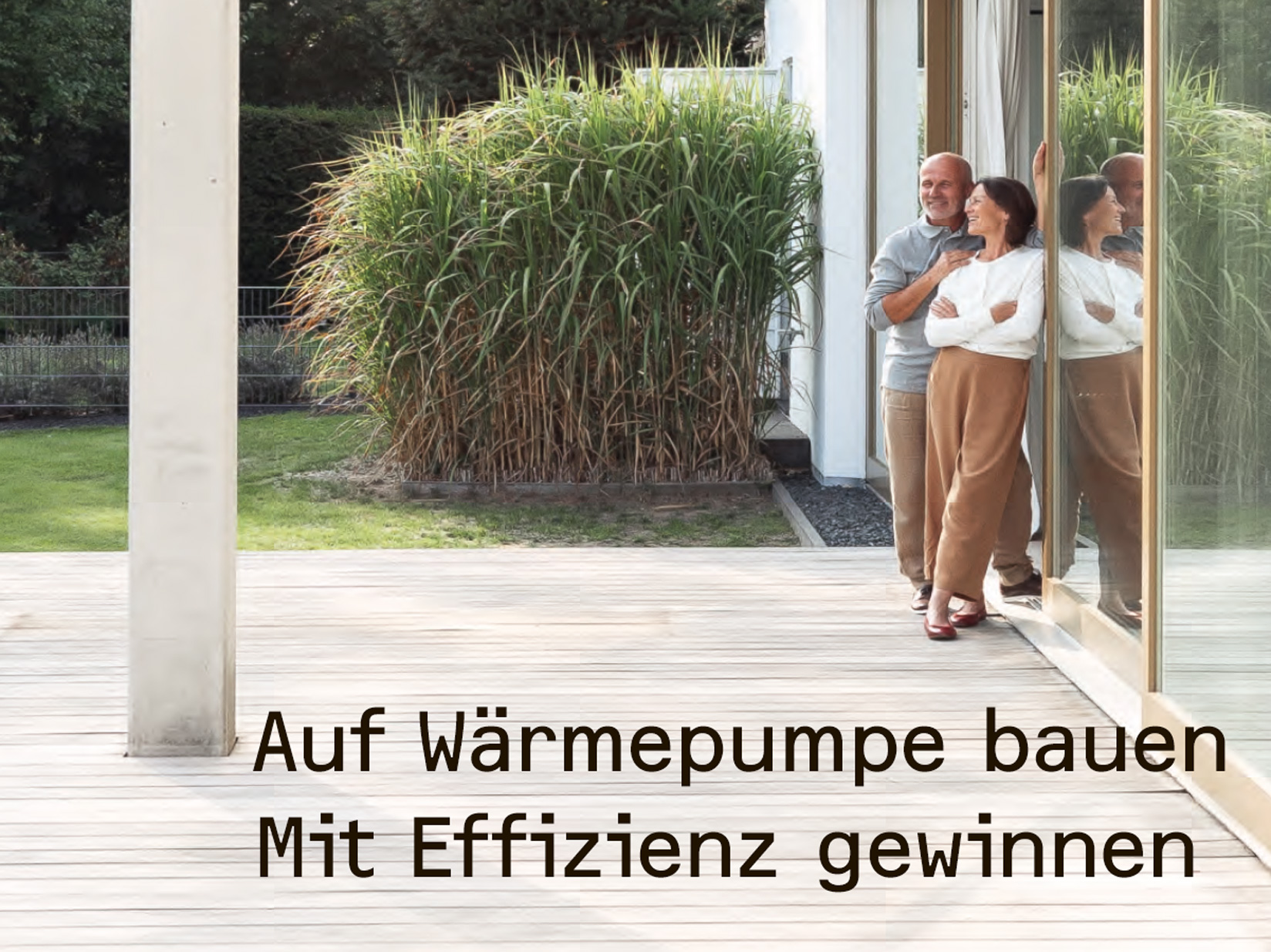 Ein Paar steht auf ihrer Terasse ihres Hauses und schaut in den Garten, auf dem Bild ist der Zweiklang: Auf Wärmepumpe bauen, mit Effizienz gewinnen platziert