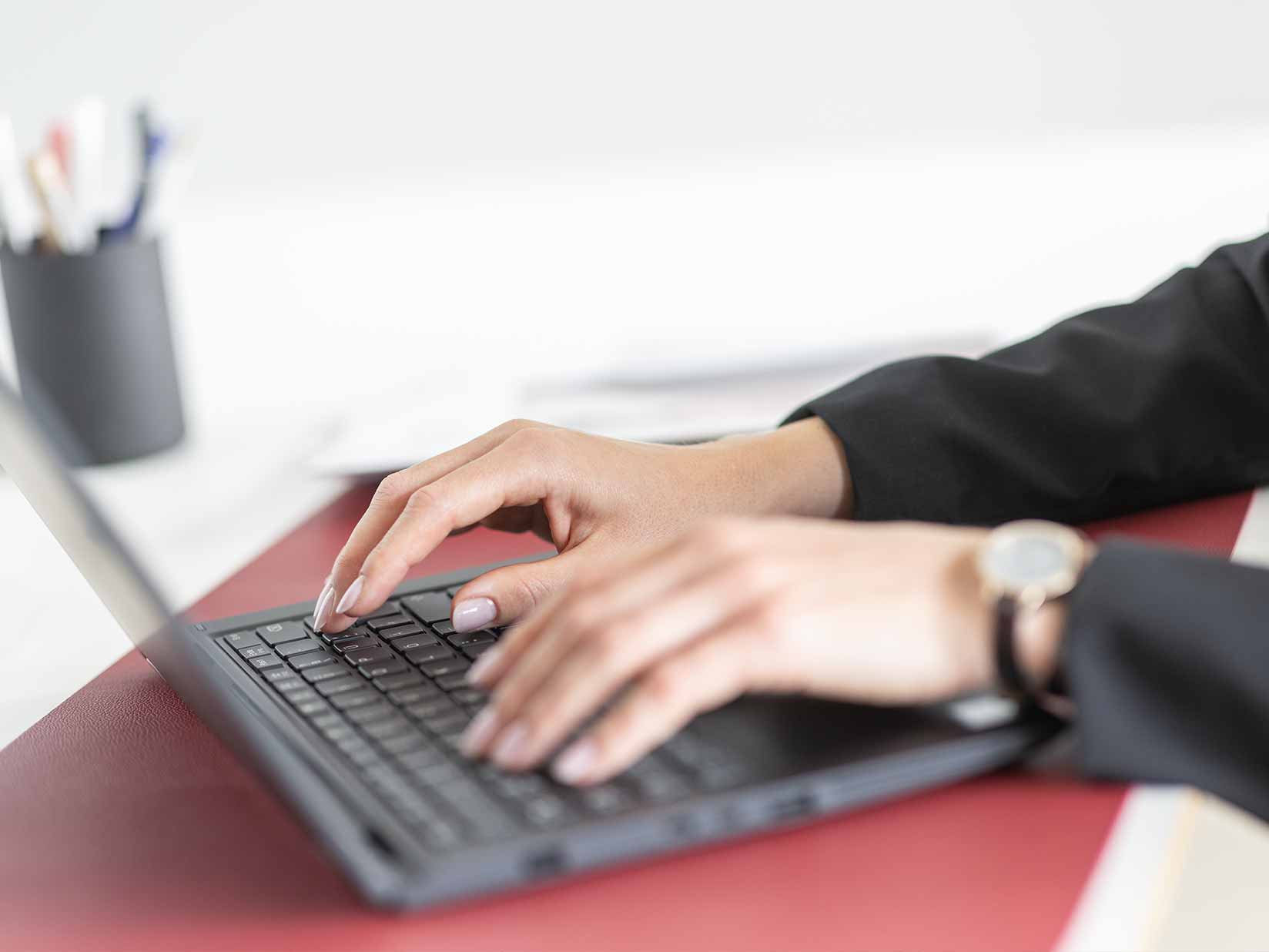 Hände schreiben auf der Tastatur eines Laptops
