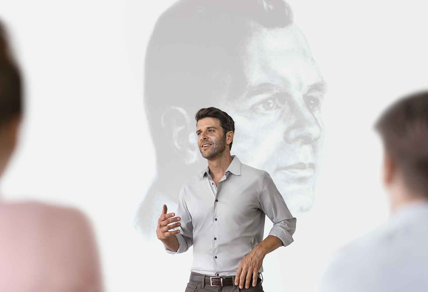 Ein Mitarbeiter präsentiert vor einer Leinwand