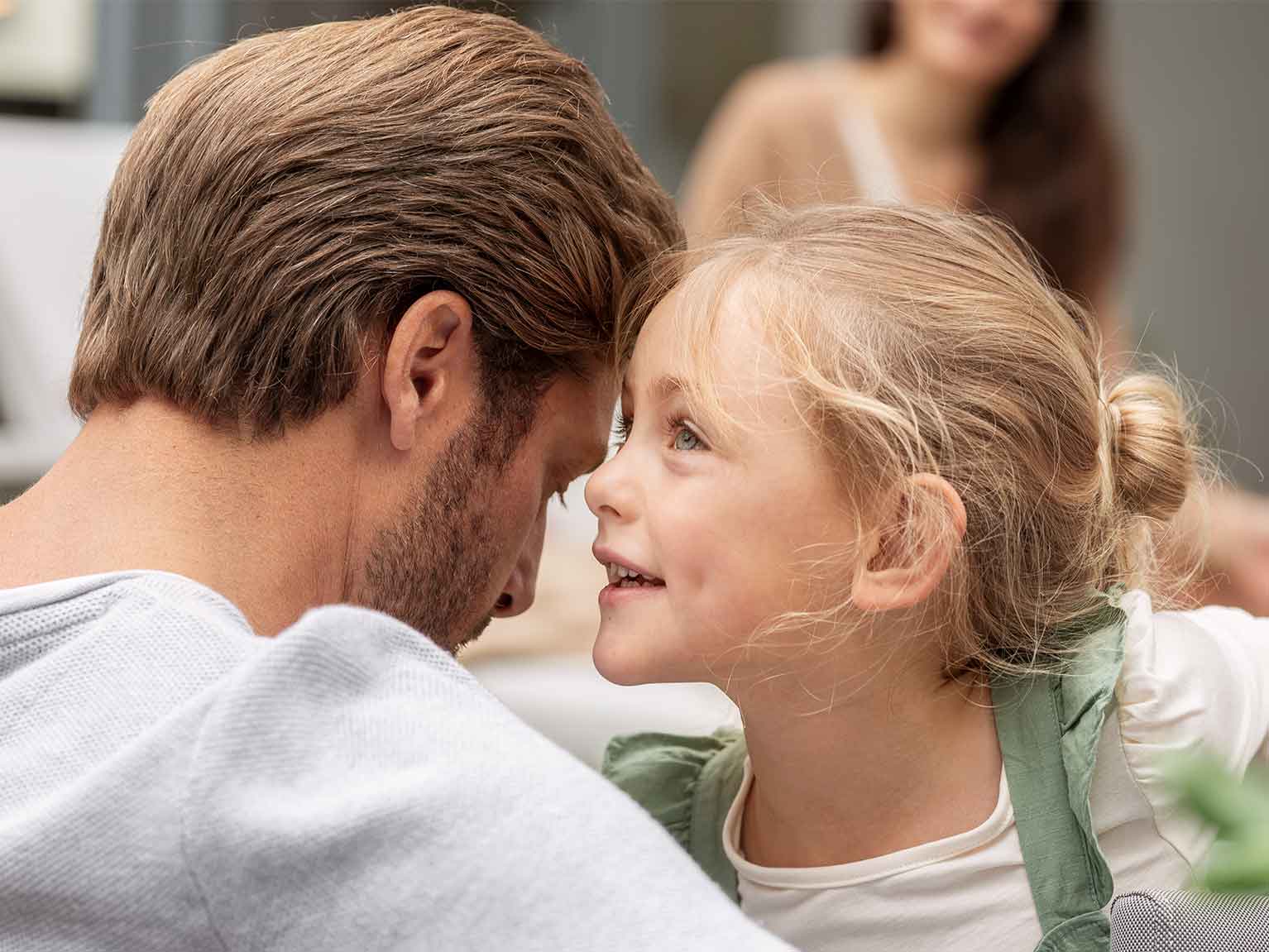Mädchen flüstert ihrem Papa etwas ins Ohr
