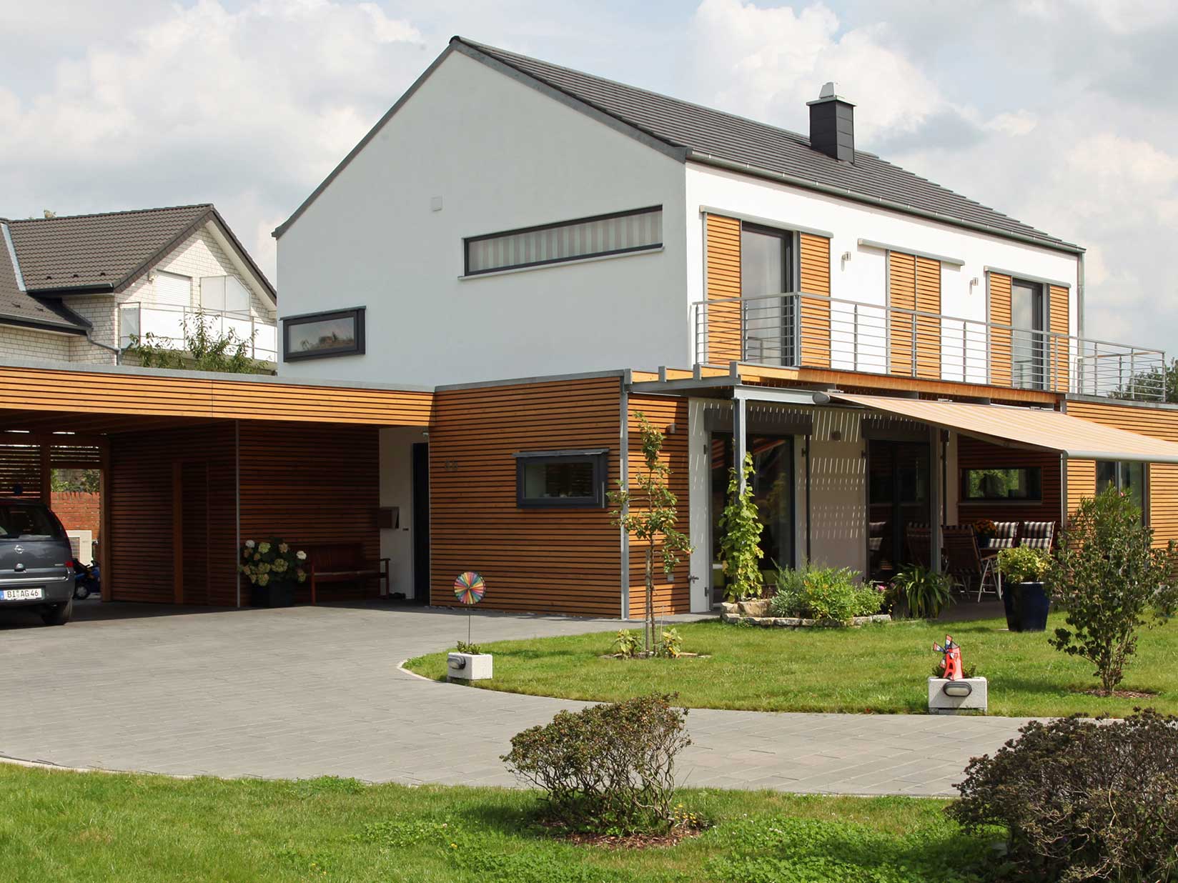 Modernes Einfamilienhaus mit Holzverkleidung und Carport