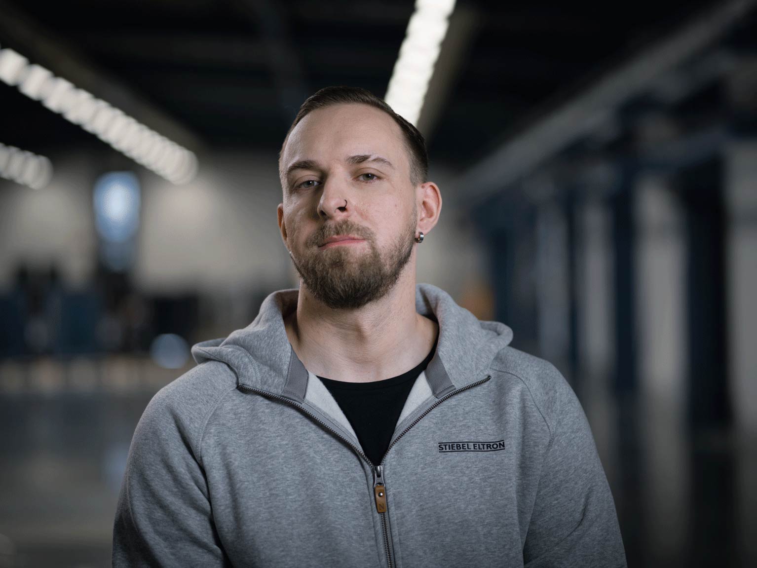 Ein STIEBEL ELTRON Mitarbeiter steht in einer modernene Produktionshalle für Wärmepumpen.
