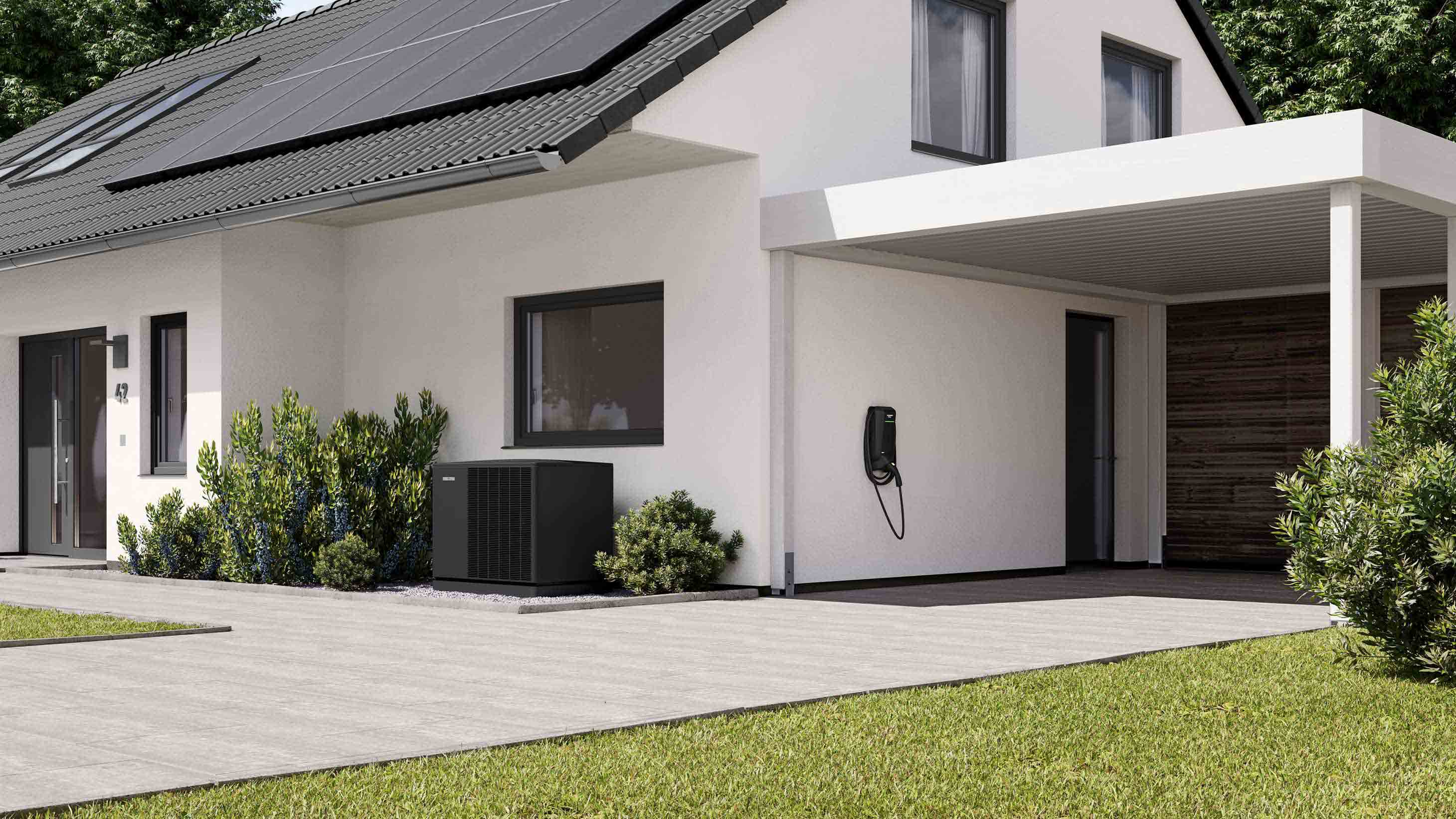 Wärmepumpe vor Haus mit Photovoltaik und Wallbox
