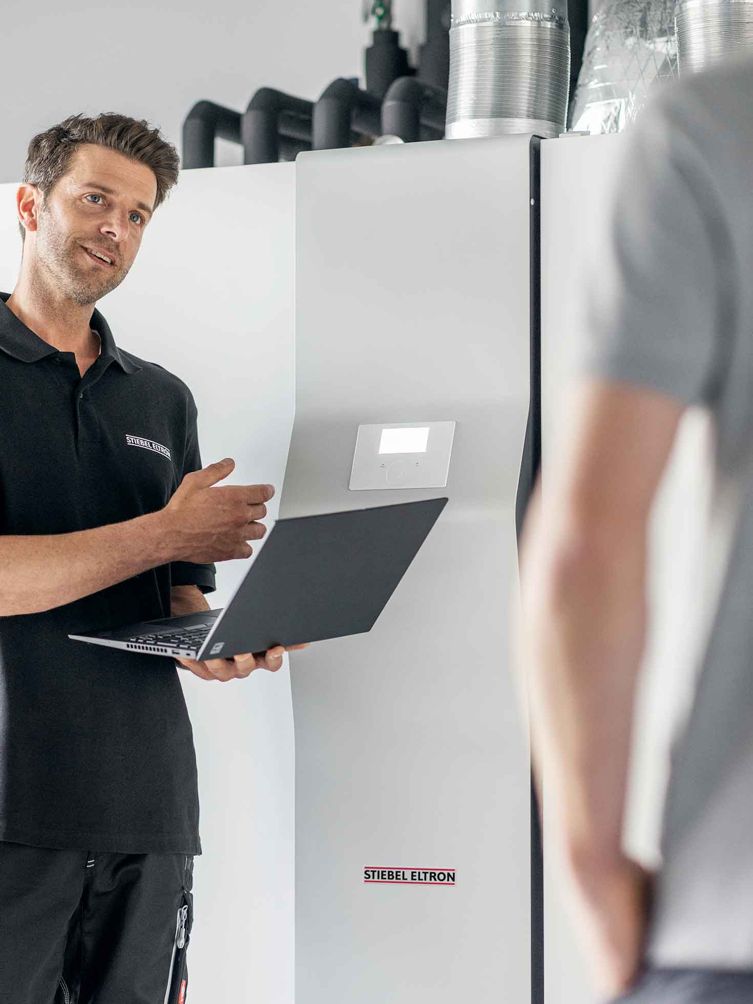 STIEBEL ELTRON-Kundendiensttechniker erklärt Kunden den Ablauf der Wartung der Wärmepumpe