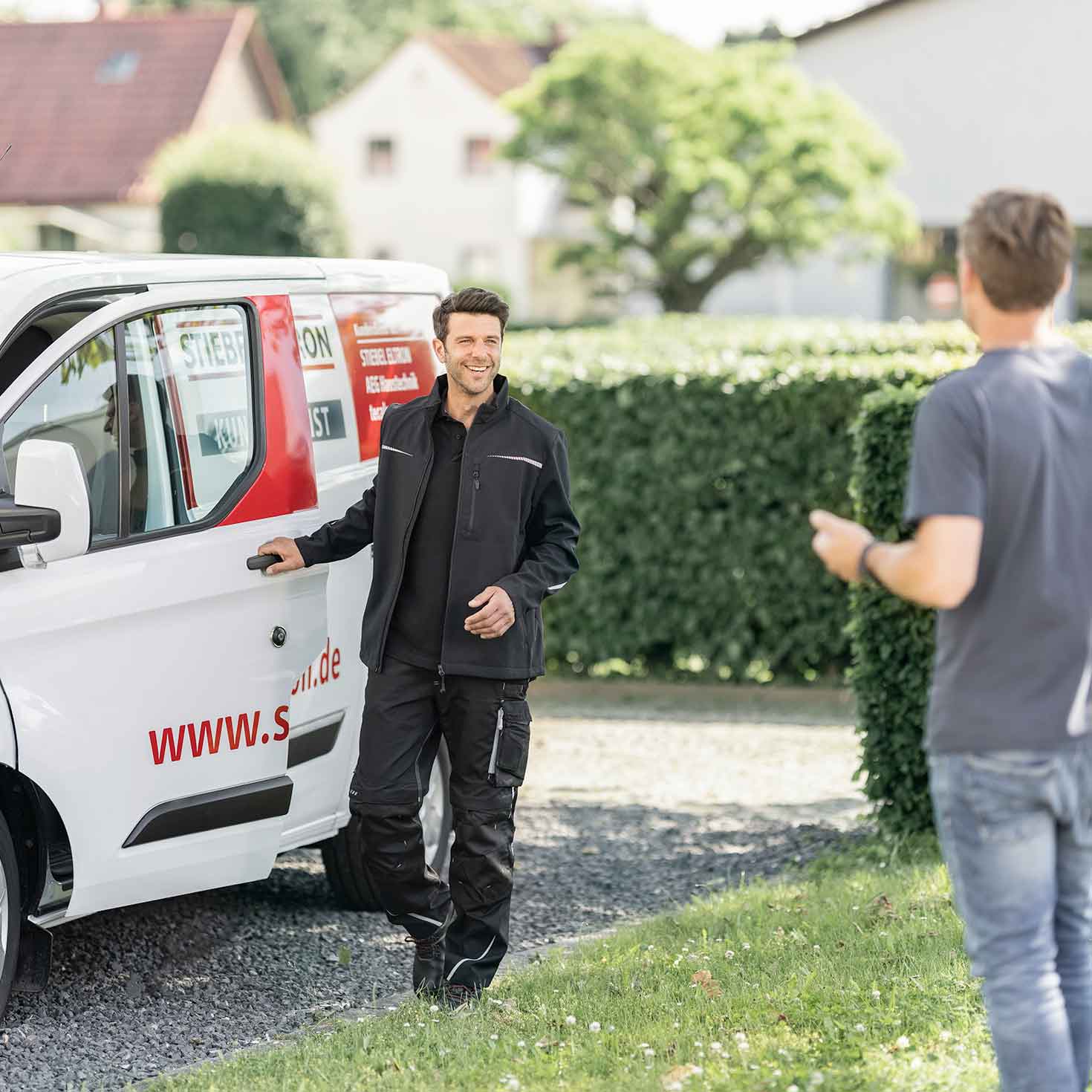 STIEBEL ELTRON-Kundendiensttechnilker steigt aus dem Auto und grüßt Kunden